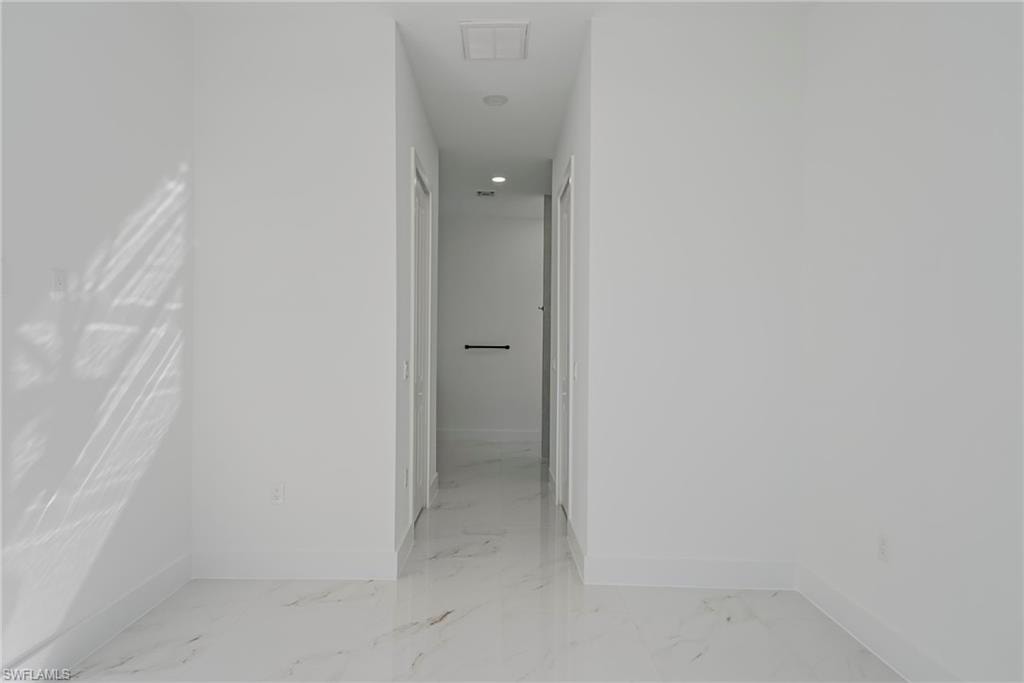 Hall with baseboards and recessed lighting