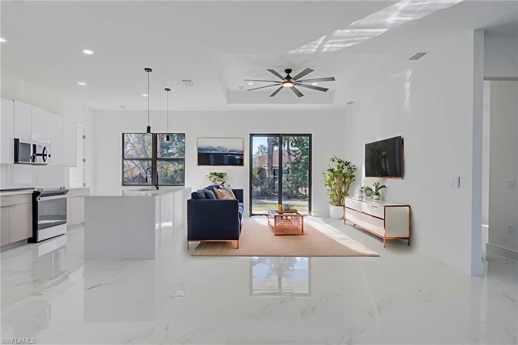 Living room with healthy amount of natural light, light marble finish flooring, recessed lighting, and a ceiling fan