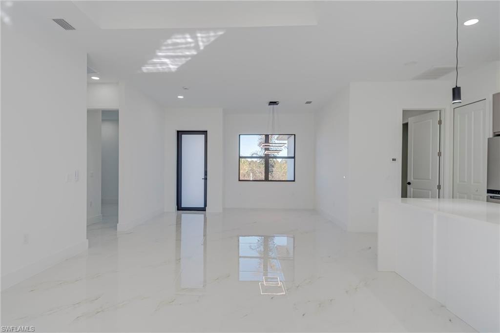 Spare room featuring light marble finish floors and recessed lighting