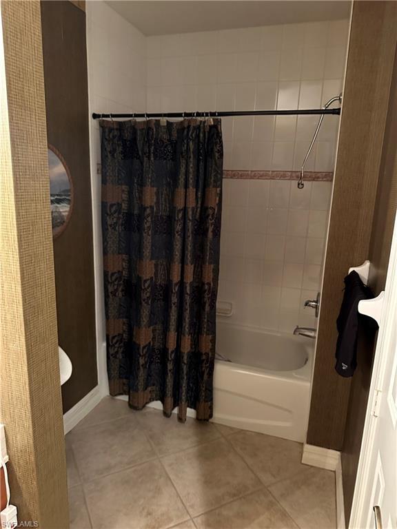 Full bath with shower / bathtub combination with curtain, light tile patterned floors, and vanity