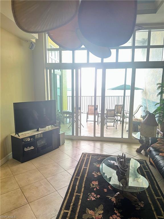 Living area with expansive windows, a high ceiling, and tile patterned floors