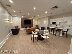 Living room with light wood finished floors and recessed lighting