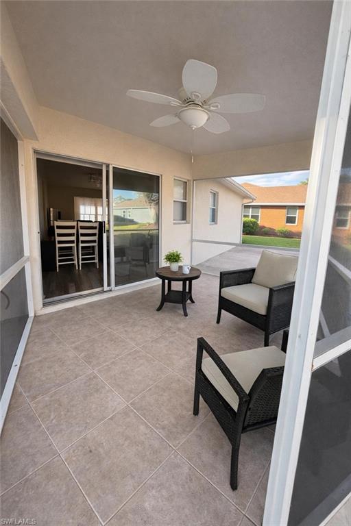 Sunroom with ceiling fan, a patio, and healthy amount of natural light