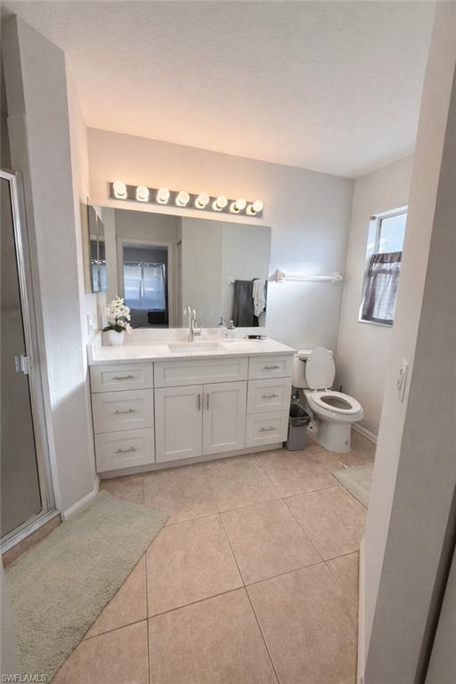 Bathroom with vanity, a stall shower, and light tile patterned floors