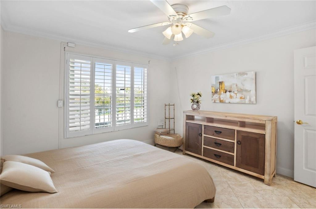 Guest-Bedroom-partial staged- featuring crown molding and a ceiling fan