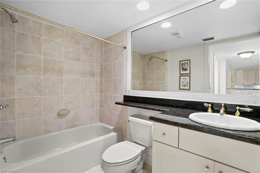 Bathroom with vanity, shower / tub combination, and recessed lighting