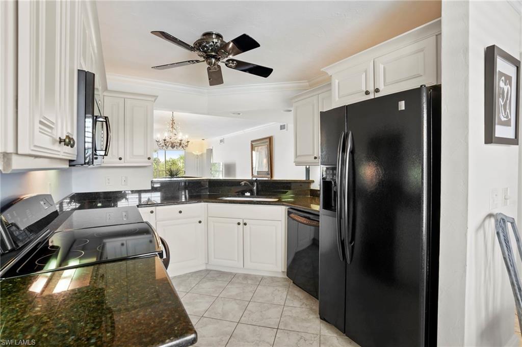 Kitchen featuring black appliances, white cabinetry, ornamental molding, a ceiling fan, and dark stone countertops