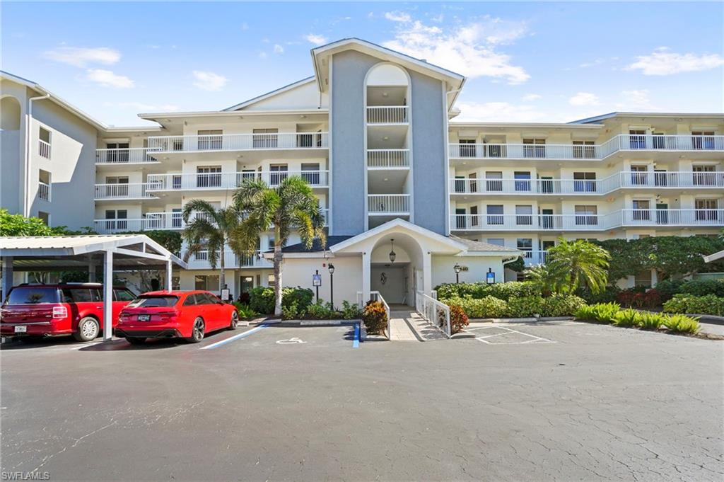 View of apartment building / complex with uncovered parking