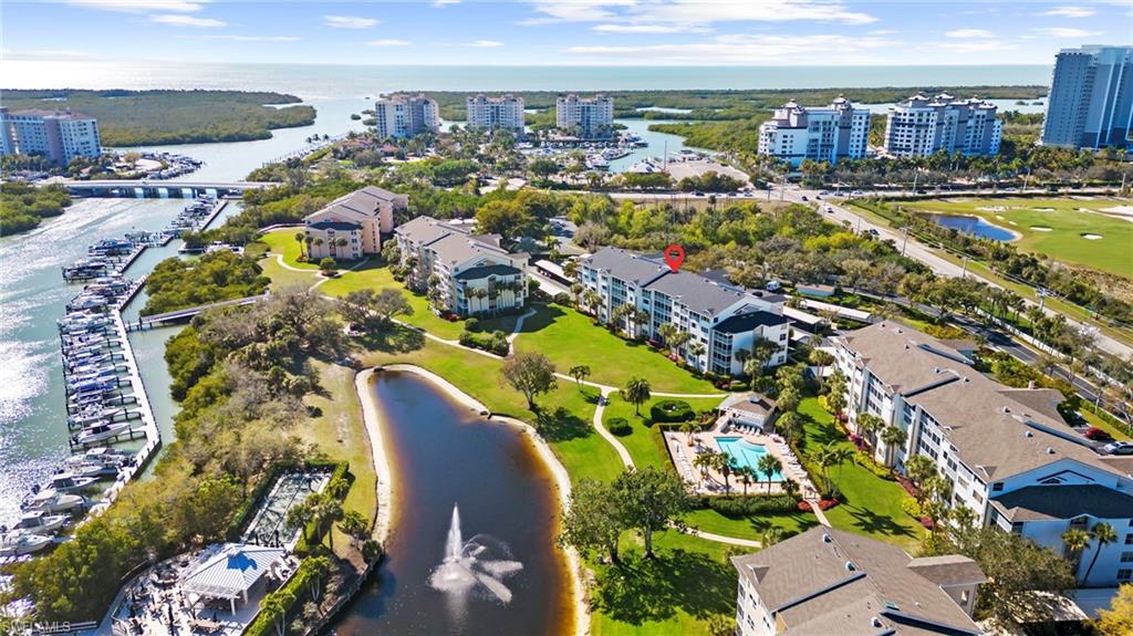 Drone / aerial view of a nearby body of water and apartment complex