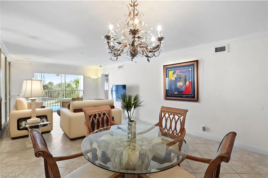 Dining area-partial staged-with ornamental molding and suspended lighting