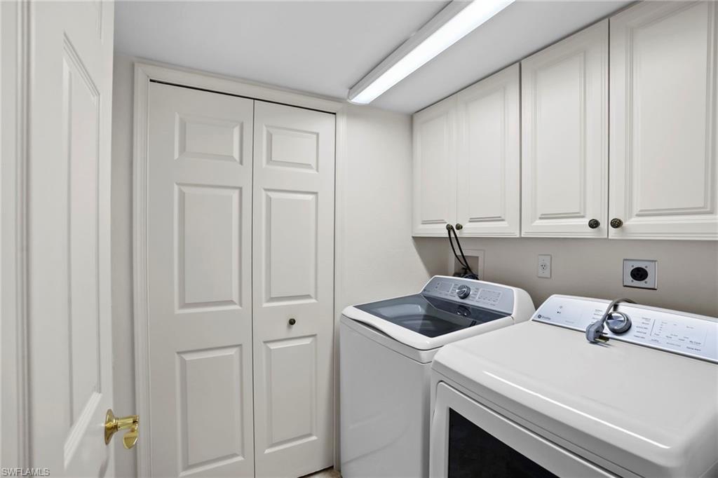 Laundry area featuring independent washer and dryer and cabinet space