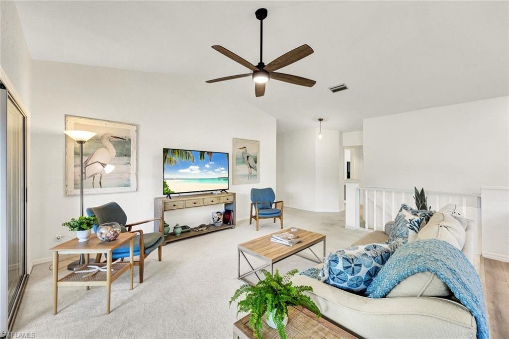 Carpeted living area with lofted ceiling and a ceiling fan