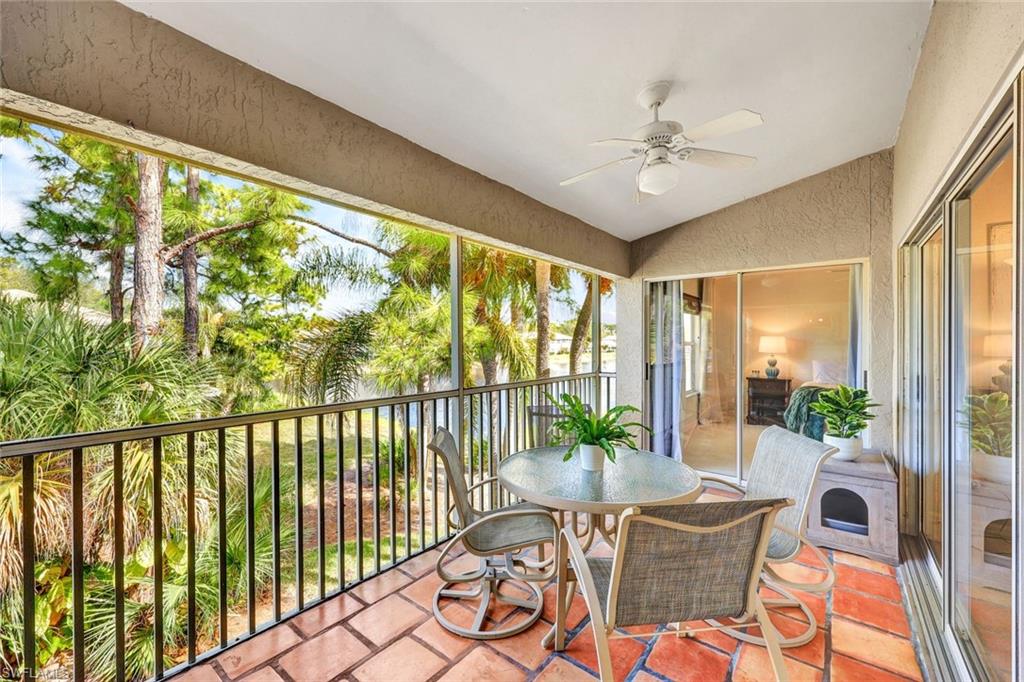 Sunroom / solarium with a ceiling fan, vaulted ceiling, outdoor dining space, a balcony, and a water view
