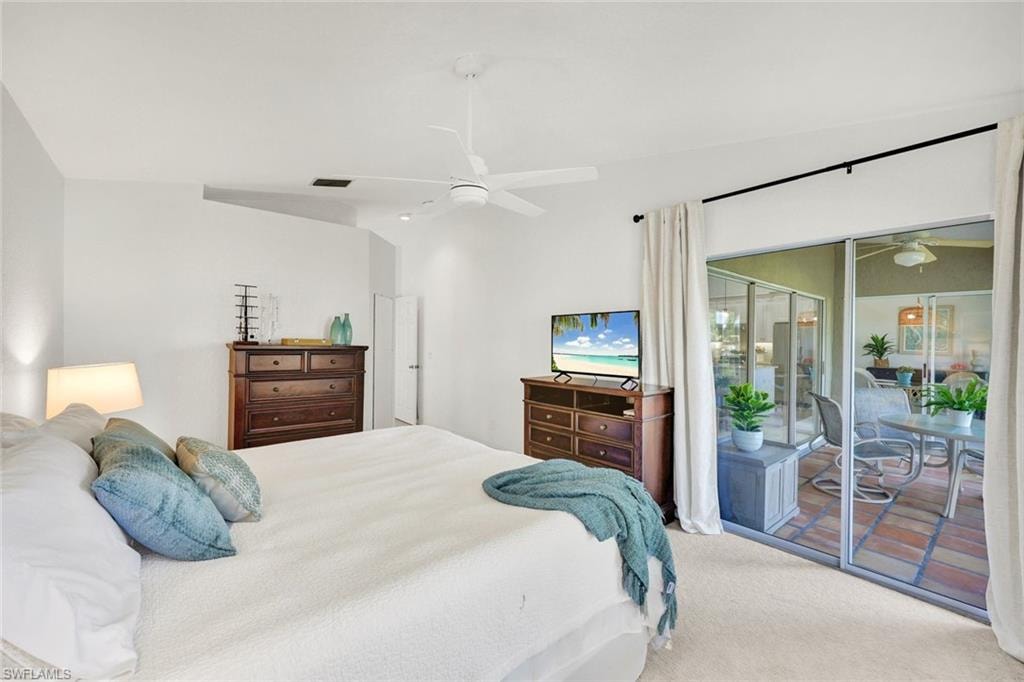 Carpeted bedroom with ceiling fan and access to exterior