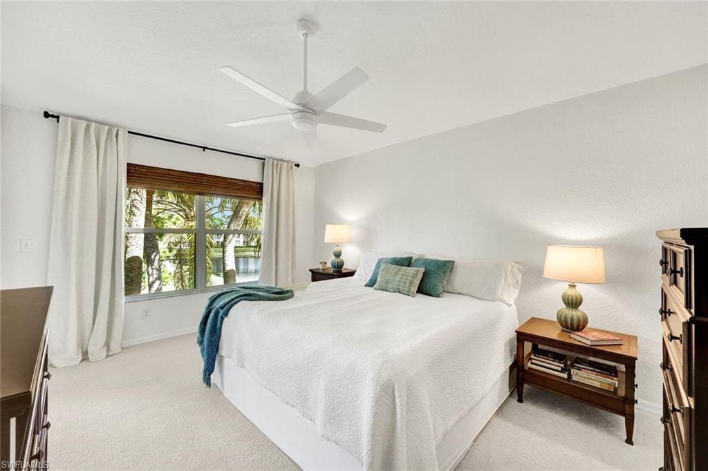 Bedroom with light colored carpet and a ceiling fan