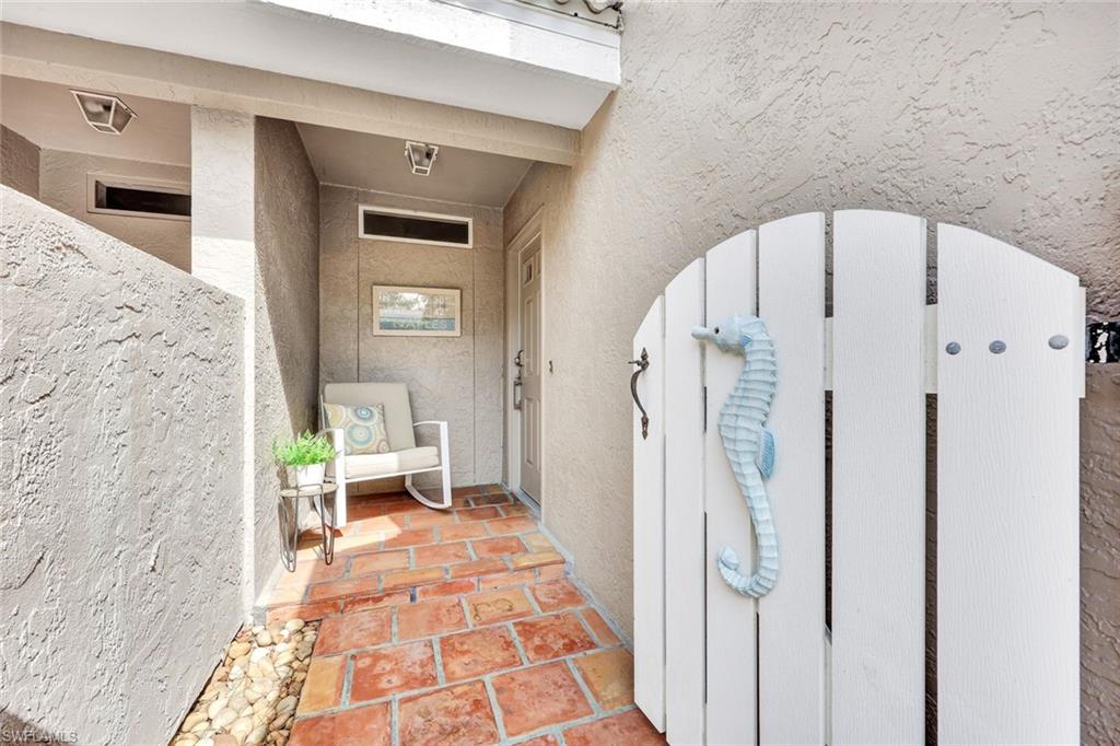 View of exterior entry featuring a gate and stucco siding