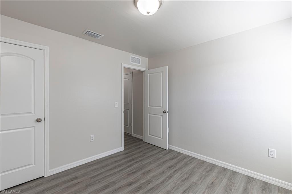 Unfurnished bedroom with baseboards and wood finished floors