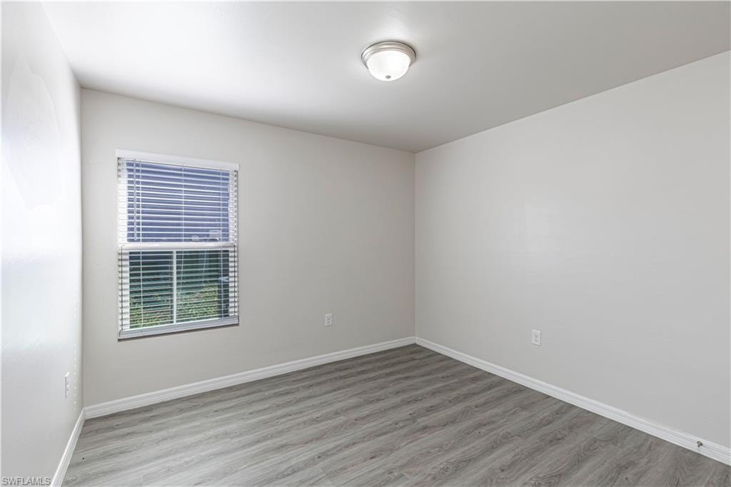 Unfurnished room with light wood-type flooring and baseboards