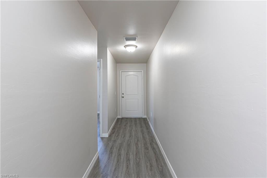 Hall with baseboards and wood finished floors