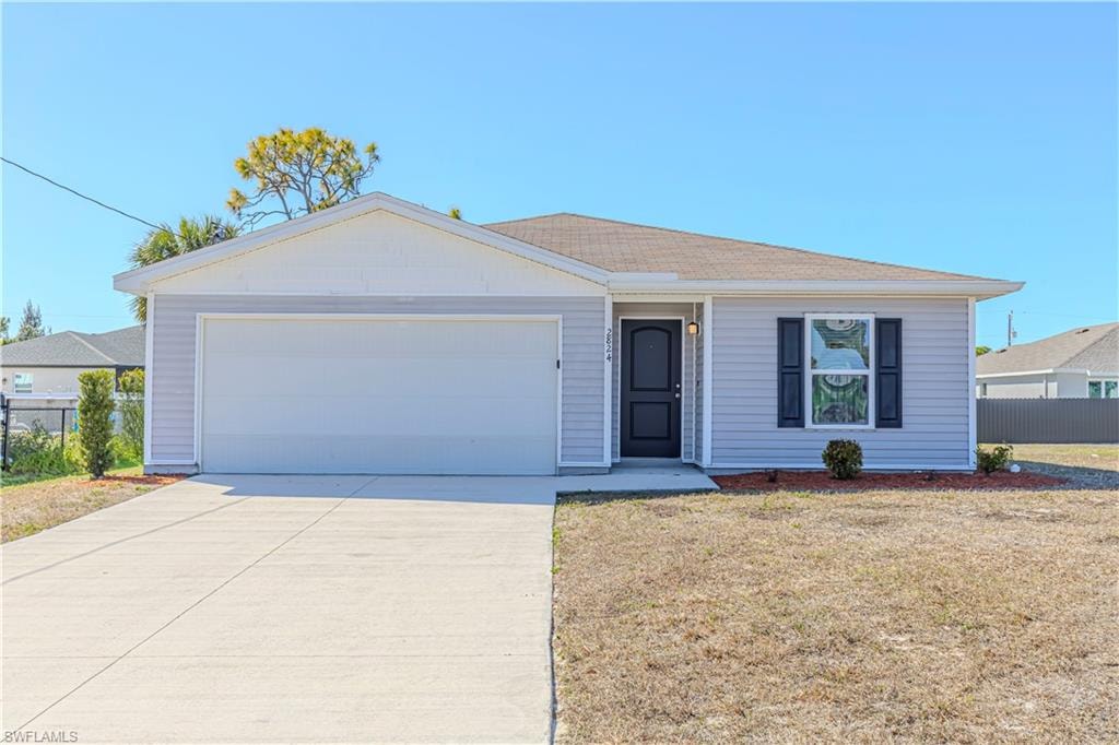 Single story home featuring an attached garage and concrete driveway