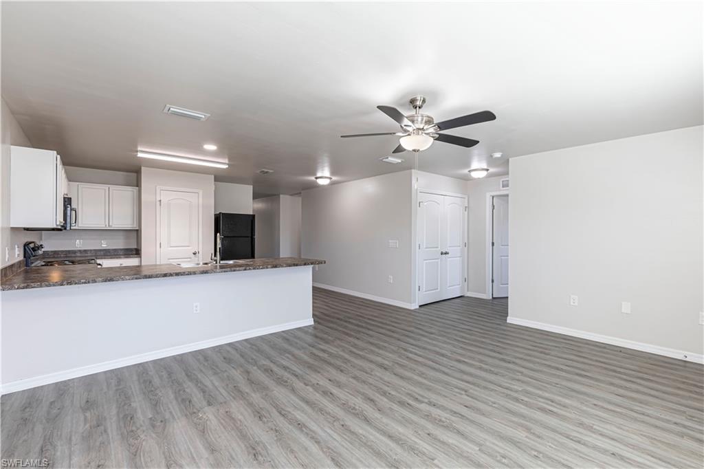 Unfurnished living room with light wood-style flooring and ceiling fan