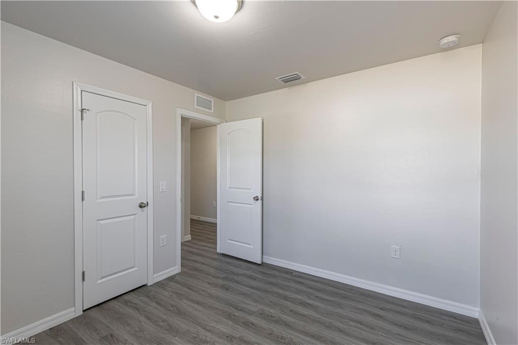 Unfurnished bedroom featuring baseboards and wood finished floors