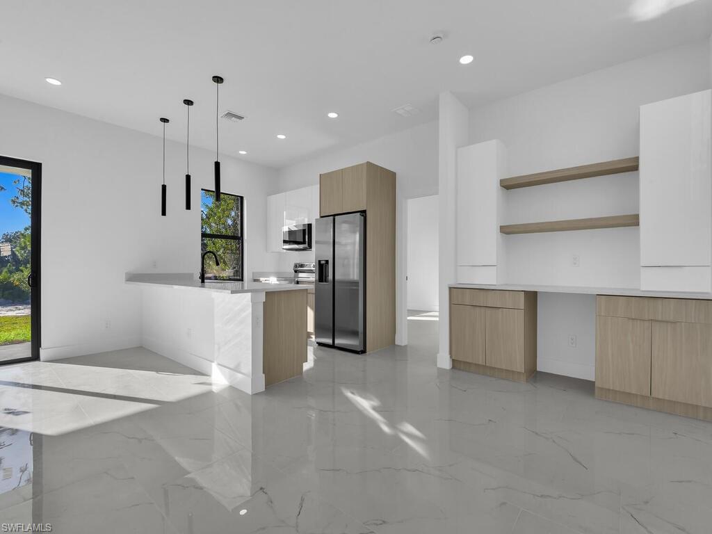Kitchen featuring open shelves, modern cabinets, stainless steel appliances, a peninsula, and pendant lighting