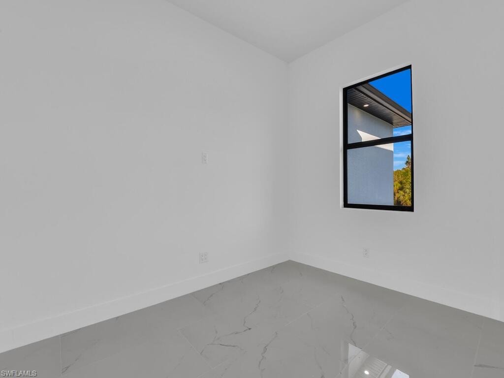 Empty room featuring baseboards and marble finish floors