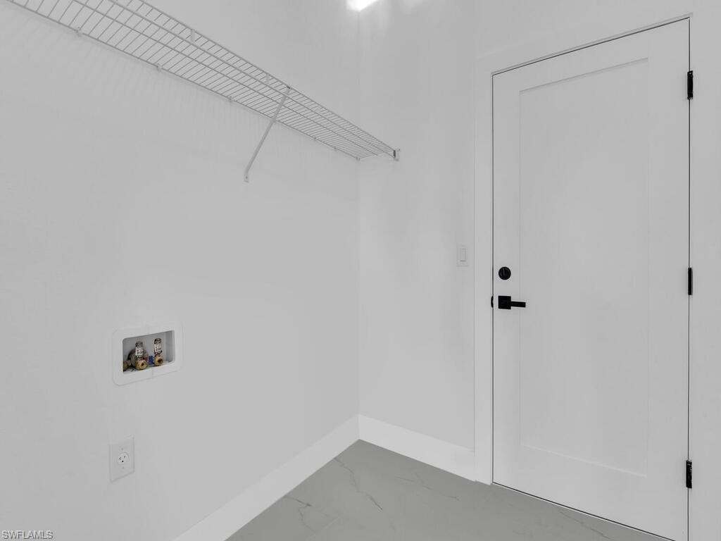 Laundry area featuring washer hookup and marble finish floors