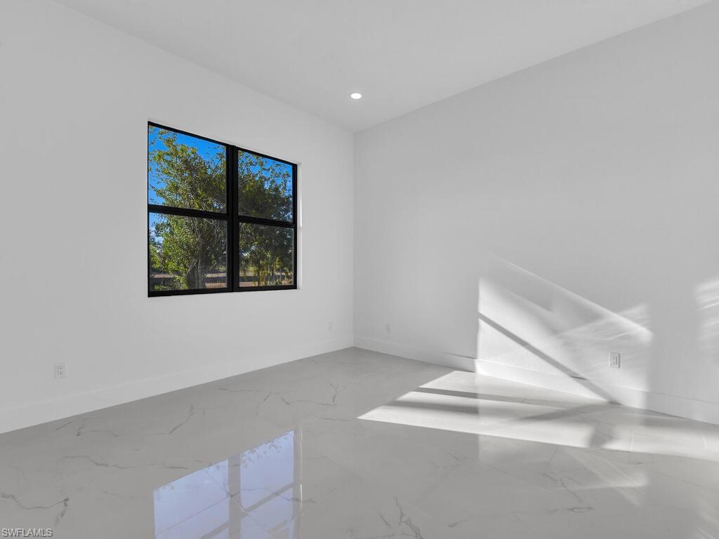 Unfurnished room with light marble finish floors and recessed lighting