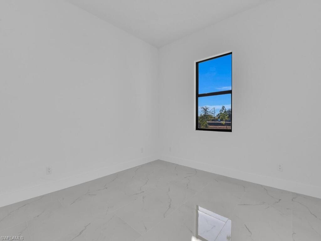 Spare room featuring baseboards and marble finish floors