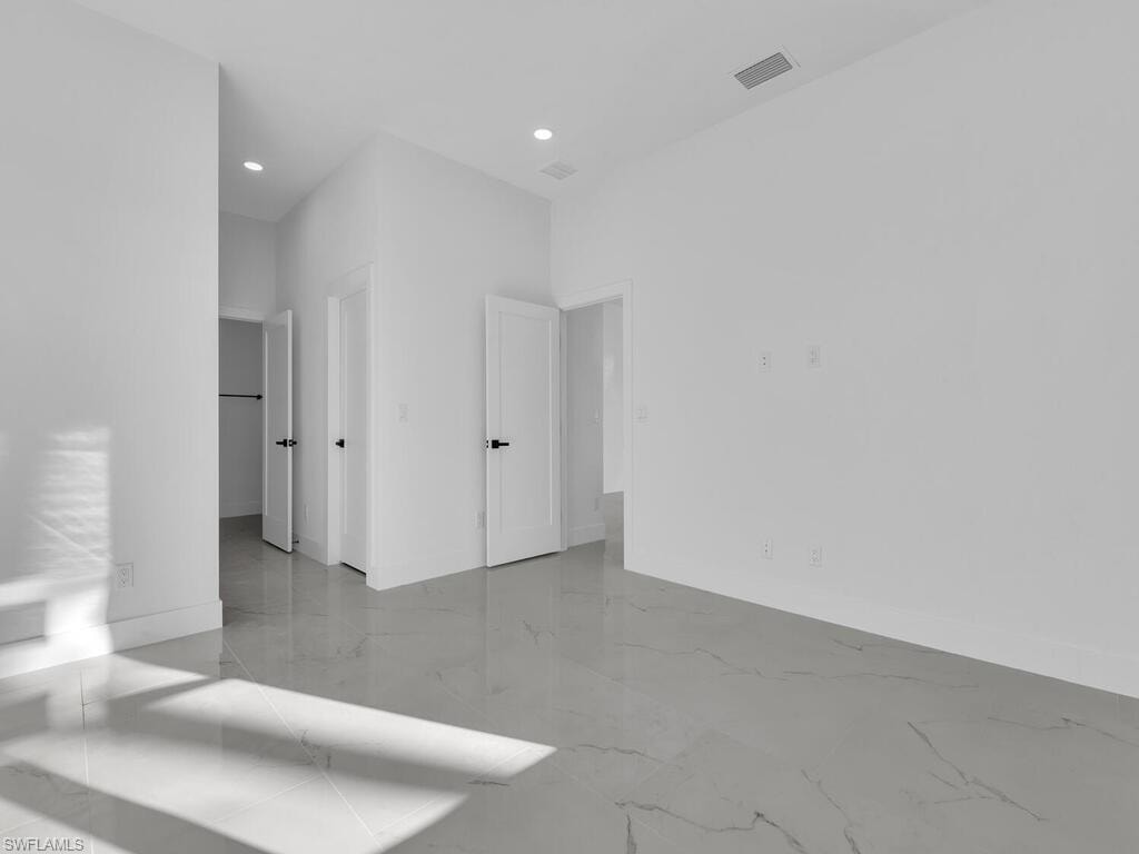 Unfurnished bedroom with light marble finish flooring and recessed lighting