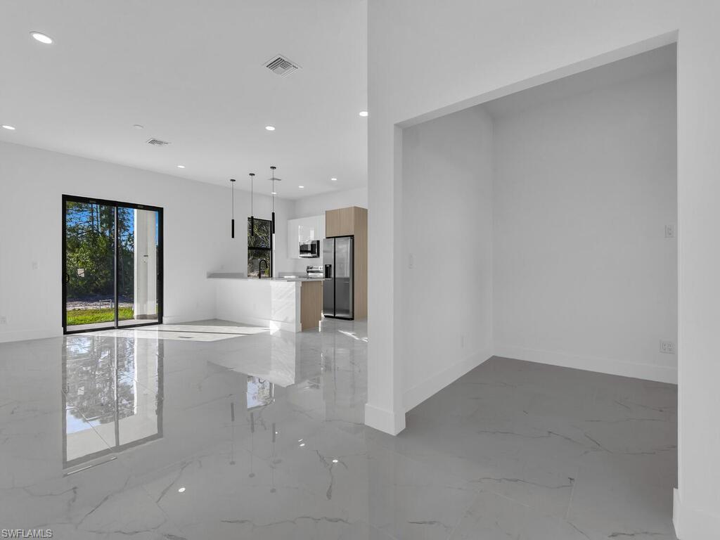 Unfurnished living room with light marble finish flooring and recessed lighting