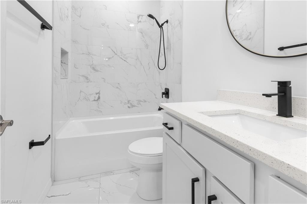 Full bathroom with vanity, tub / shower combination, and light marble finish floors