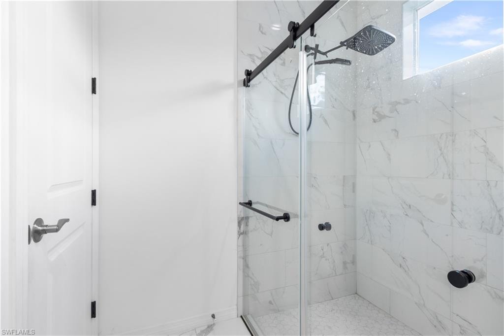 Full bath featuring a marble finish shower