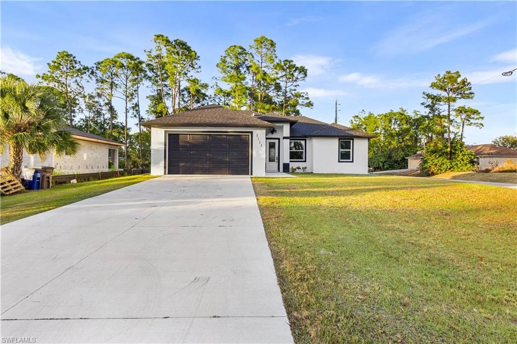 View of front of home featuring a front lawn, driveway, an attached garage, stucco siding, and a shingled roof