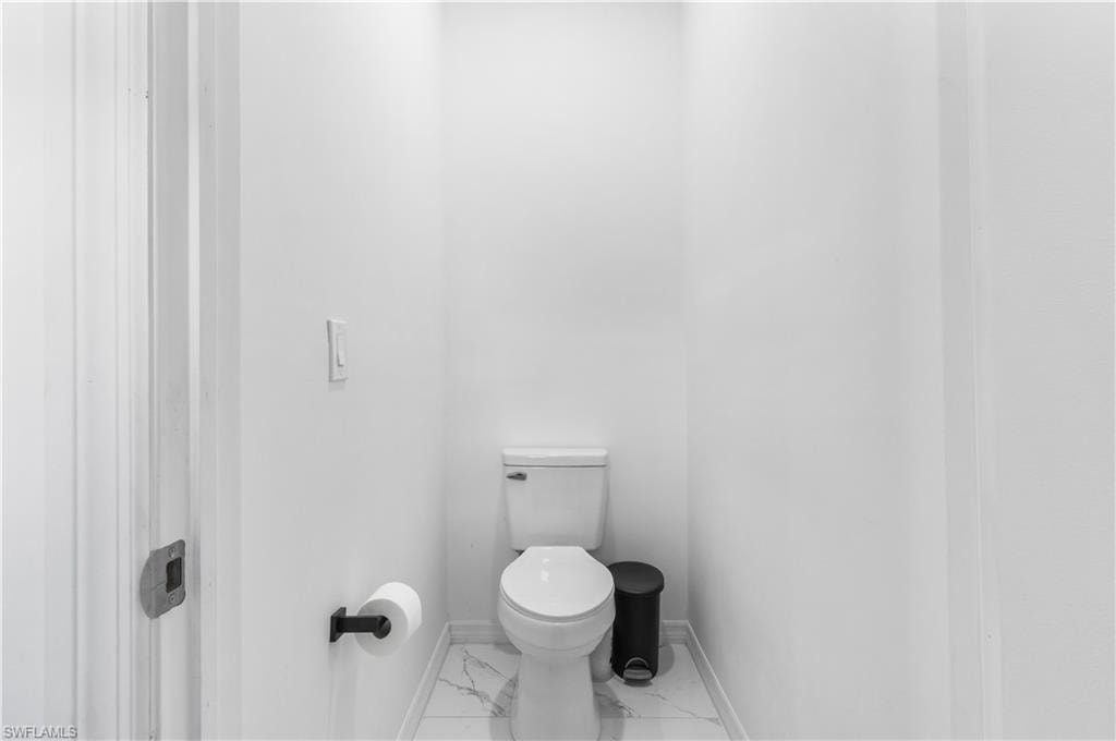 Bathroom with toilet and marble look tiles