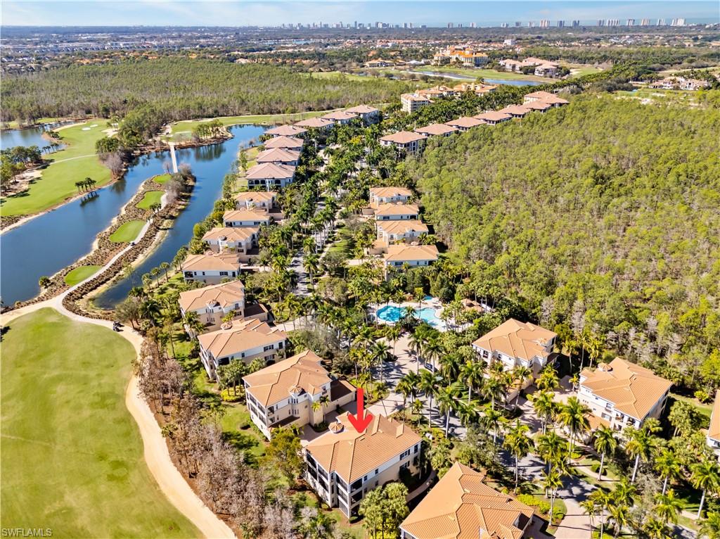 Aerial perspective of suburban area featuring a large body of water and a golf club