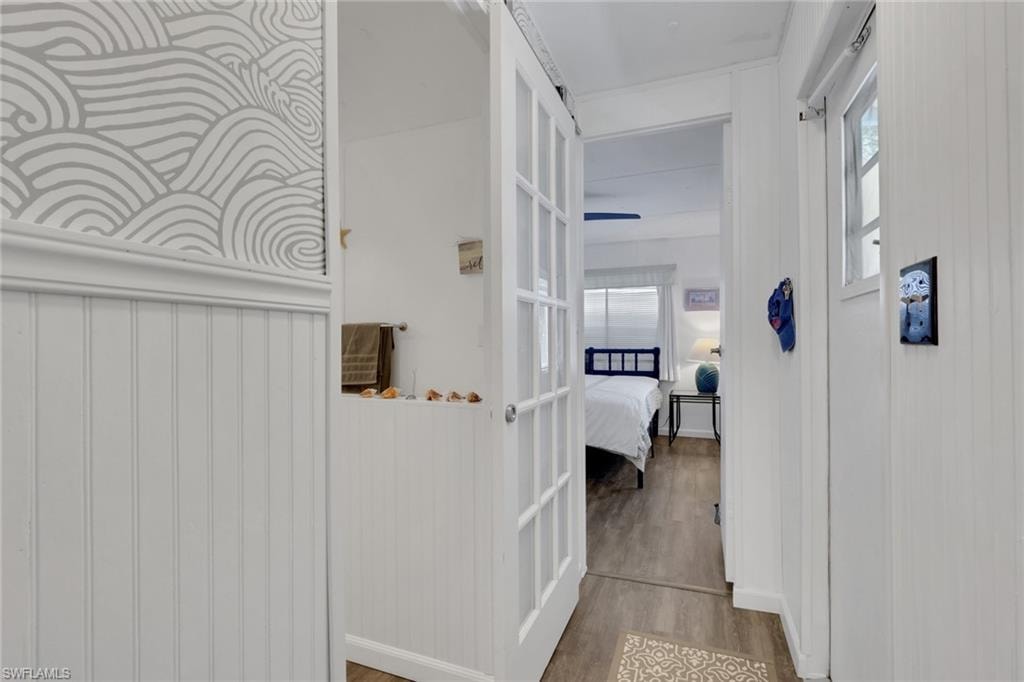 Corridor featuring wood finished floors and healthy amount of natural light