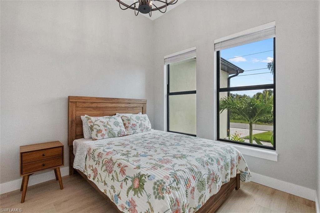 Bedroom with hanging lights and light wood finished floors