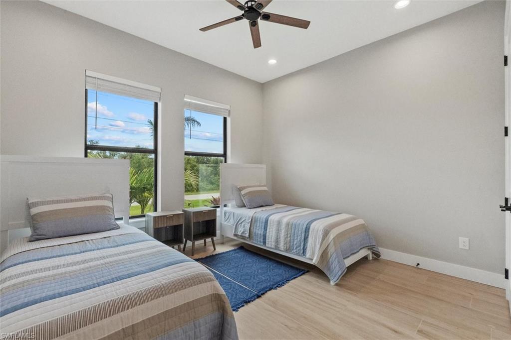 Bedroom featuring light wood-style floors, ceiling fan, and recessed lighting