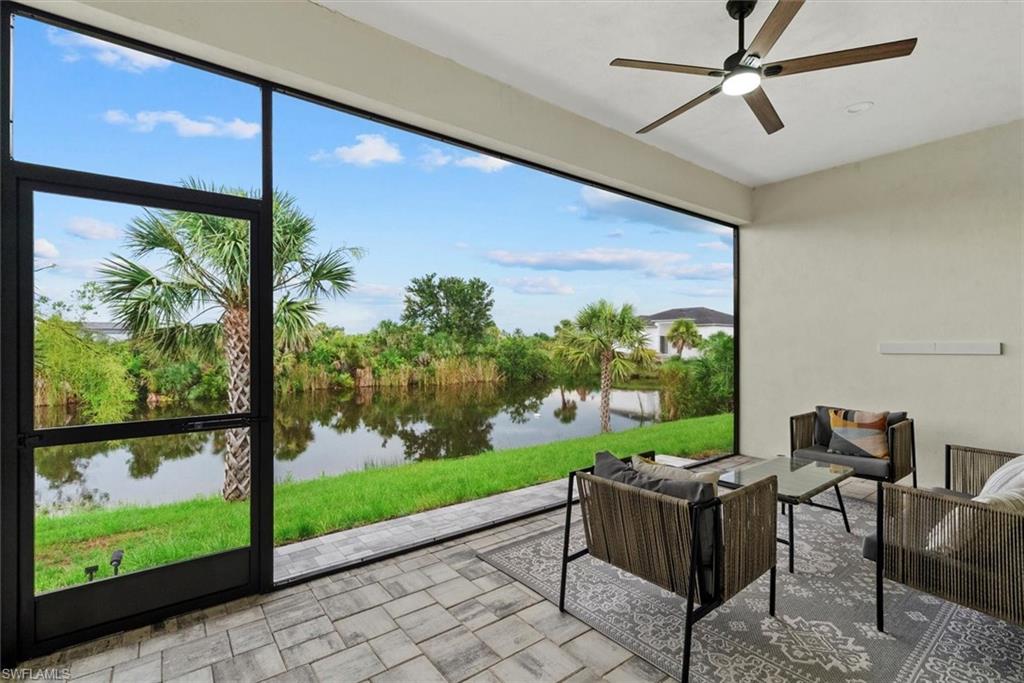 Sunroom / solarium featuring outdoor lounge area, a ceiling fan, a water view, and a patio area
