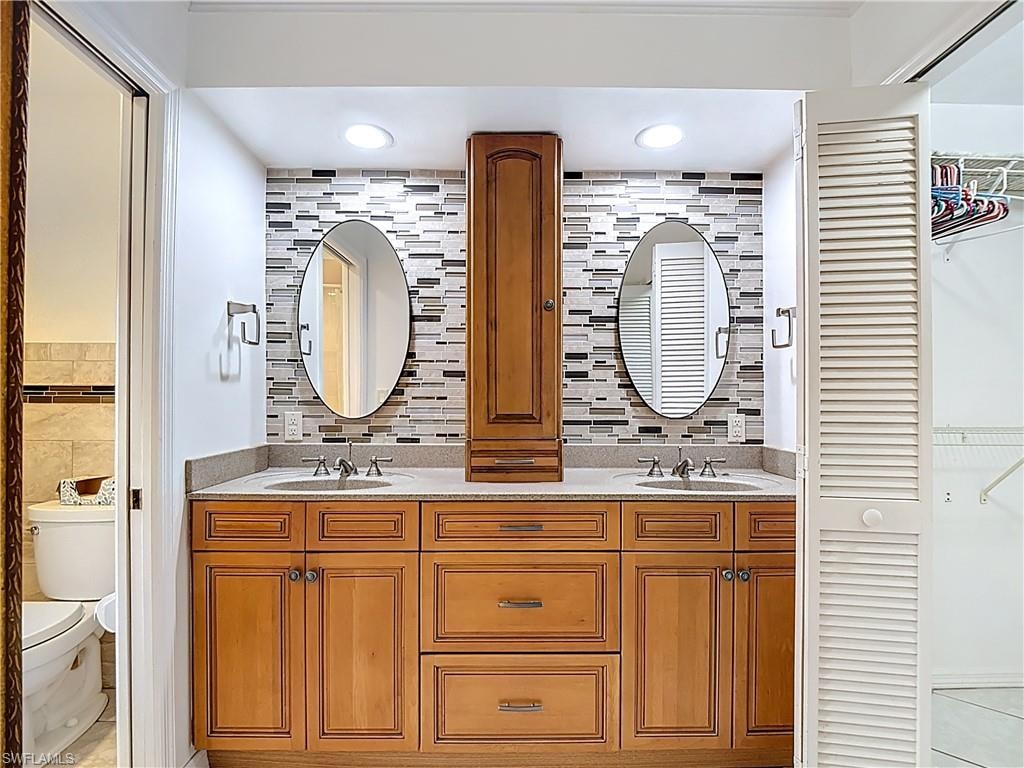 Bathroom with double vanity, tile walls, and light tile patterned floors