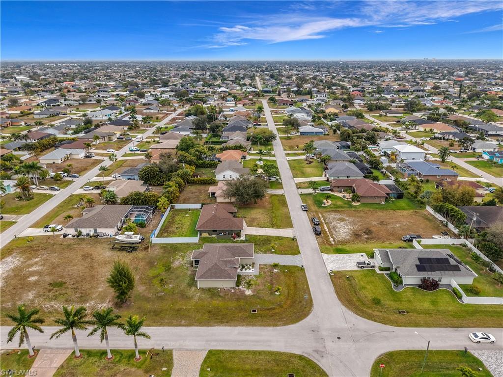 Aerial view of property and surrounding area featuring nearby suburban area
