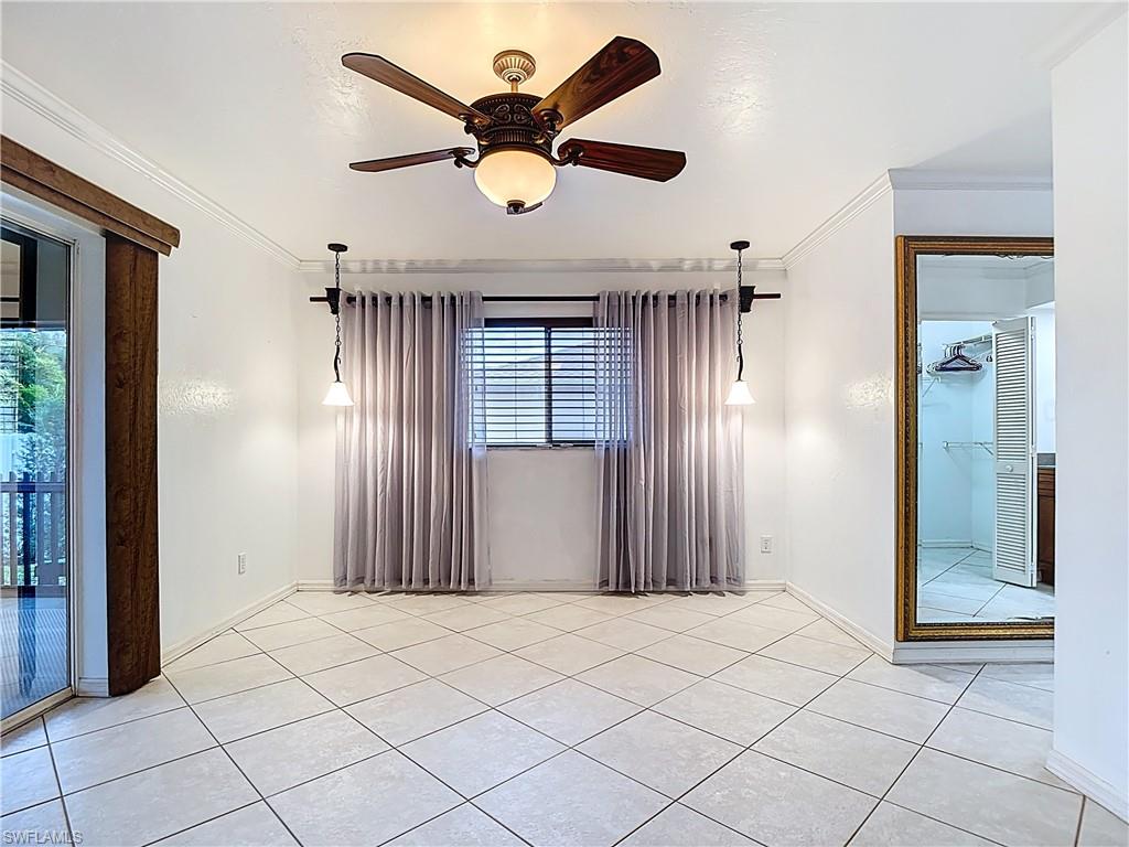 Unfurnished bedroom featuring ornamental molding, access to outside, a ceiling fan, and light tile patterned flooring