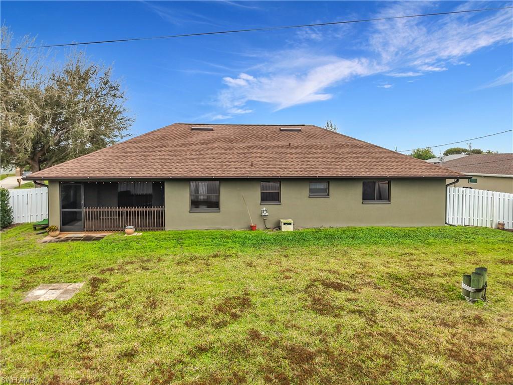 Rear view of property featuring roof with shingles, a sunroom, and stucco siding