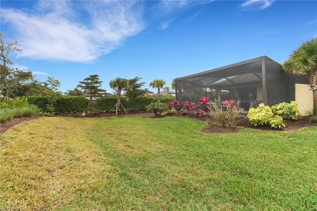 View of green lawn with glass enclosure and a sunroom