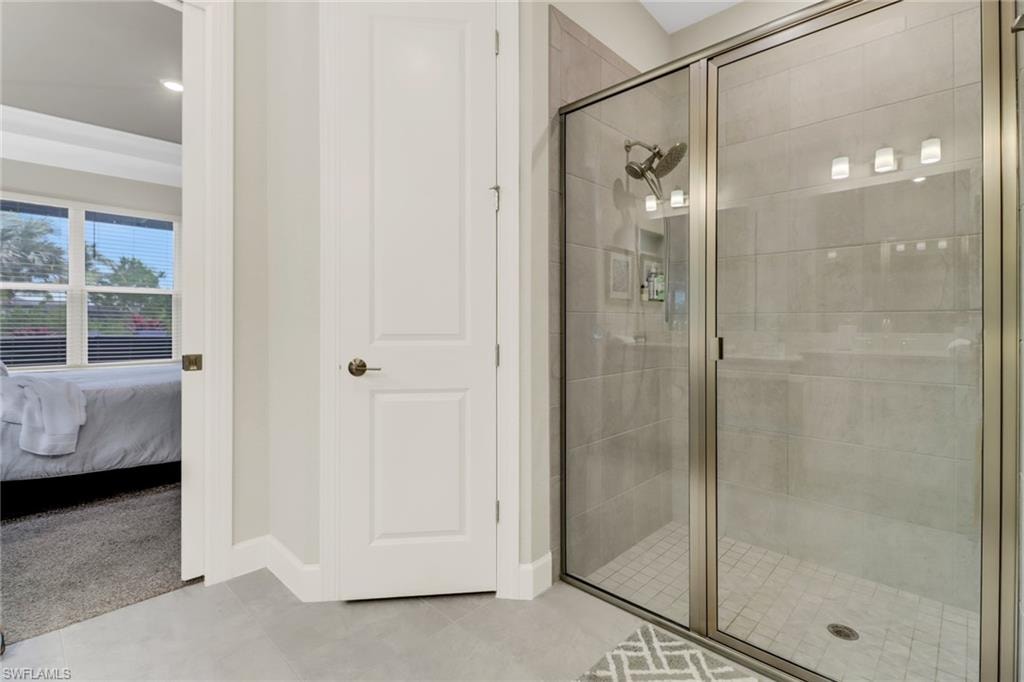Bathroom featuring ensuite bath, a shower stall, and light tile patterned floors