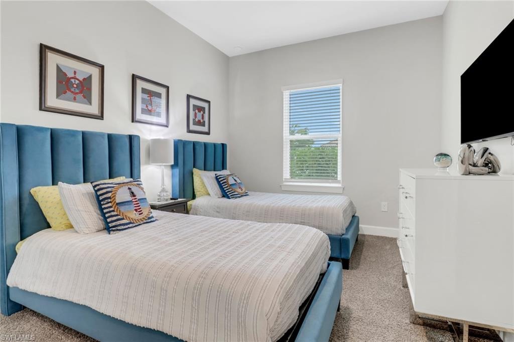 Bedroom featuring carpet and baseboards