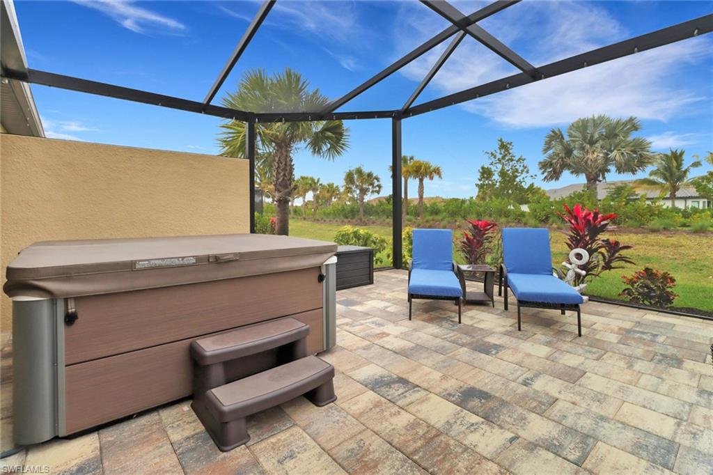 View of patio featuring a hot tub, a lanai, and a sunroom